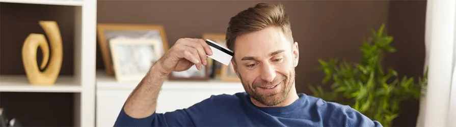 middle-aged guy thinking about what to do with expired credit card