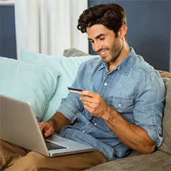 man-on-couch-with-creditcard-and-laptop-Shutterstock