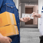 Man with boxes at doorway handing another man cash