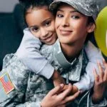 military woman with young child on her back