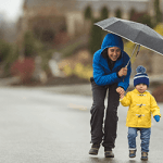 YoungMomDoesntLetTheRainStopHerFromTakingHerChildOnAWalk_GettyImages_450x250