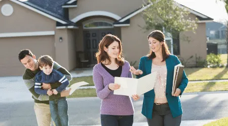 Family standing with a real estate agent