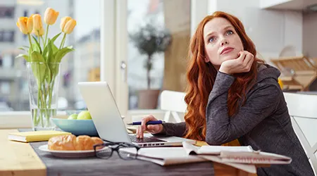 Woman working on laptop in kitchen