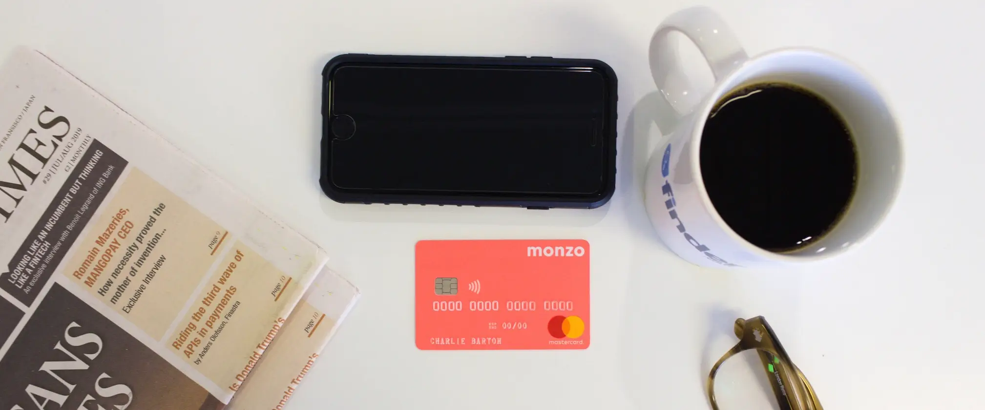 Monzo card on desk with newspaper