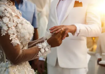 Woman putting a wedding ring on her husband's finger