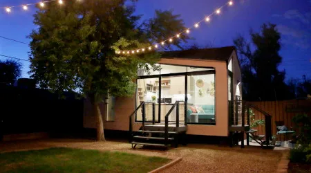 A tiny house lit up at night