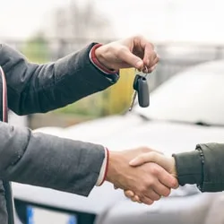Two people shaking hands exchanging car keys, buying, selling, loan, auto finance