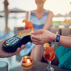 Woman paying with credit card while on tropical vacation
