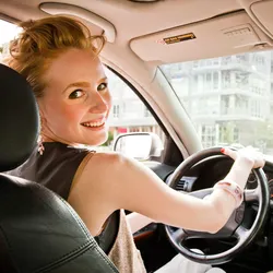 Portrait of a young woman inside her car smiling